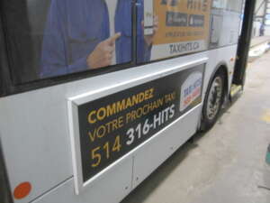 Murale Taxi HITS avec l'adresse taxihits.ca sur un autobus exo