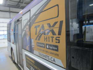 Panneau latéral Taxi HITS sous les fenêtres d'un autobus exo